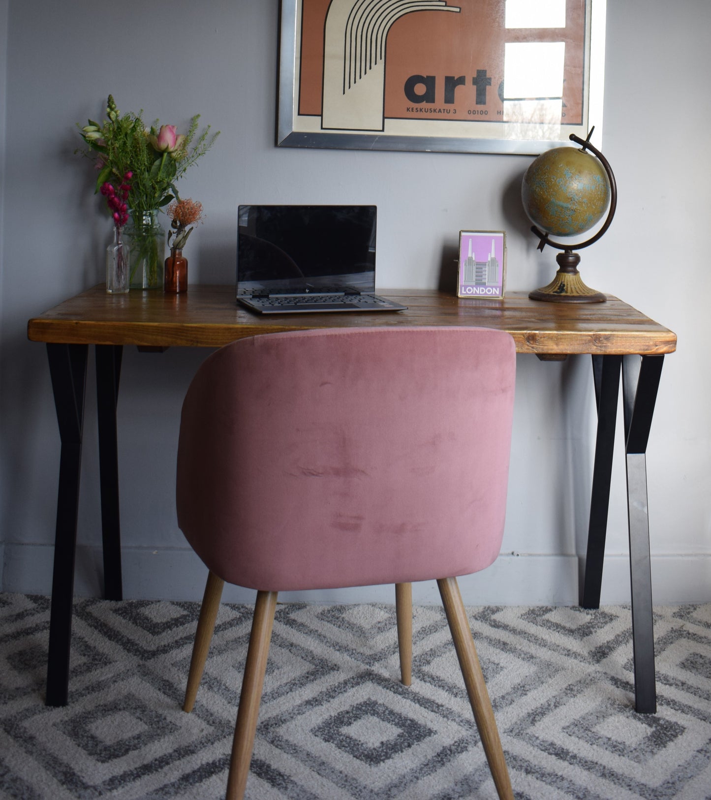 Close-up of reclaimed pine desk top with sleek black steel legs