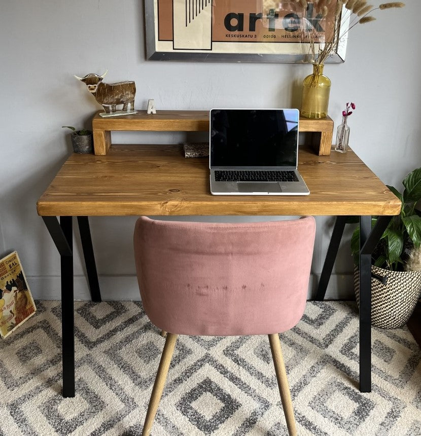 Industrial redwood pine desk with black steel legs, featuring a mid shelf and riser shelf for a stylish home office setup