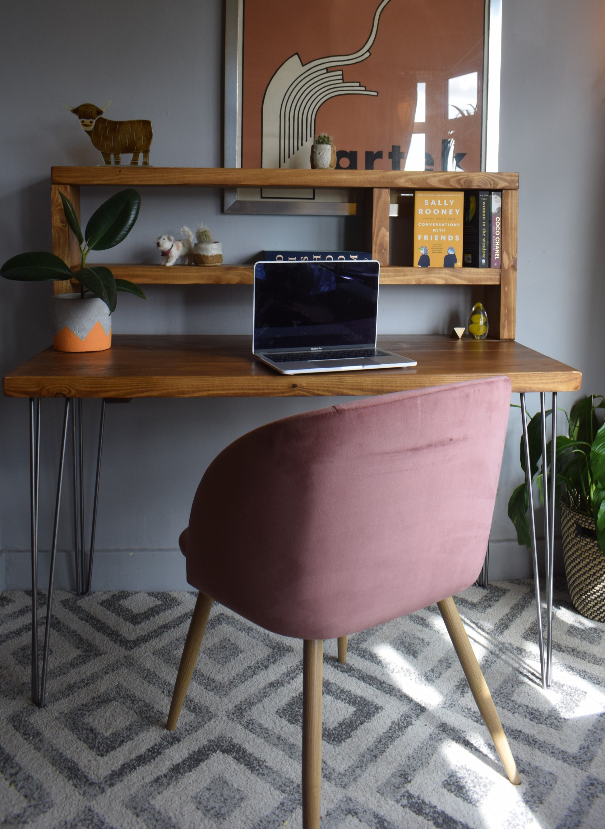 Close-up of industrial redwood pine desk with raw hairpin steel legs and a tall shelf.