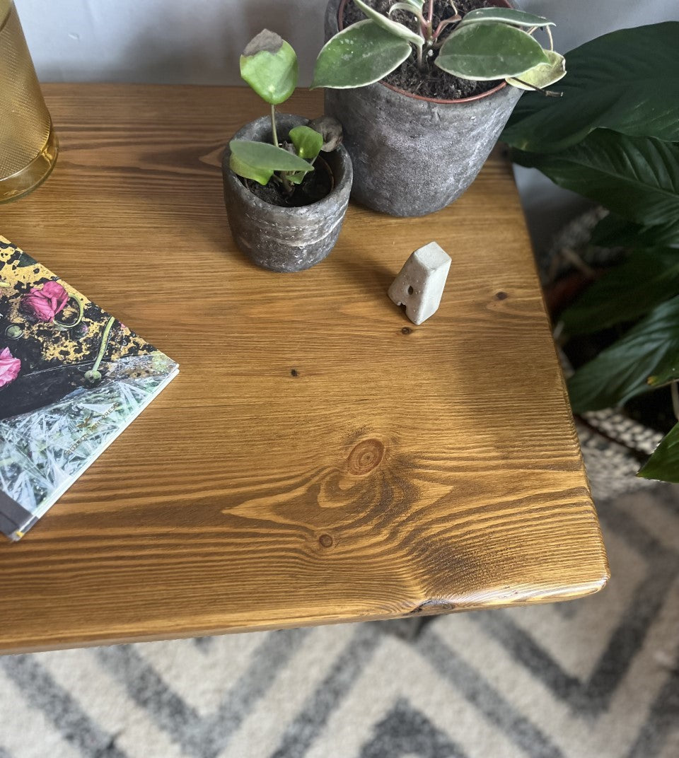 Rustic pine coffee table with sleek black steel hairpin legs, perfect for enhancing the modern and mid-century charm of your living room