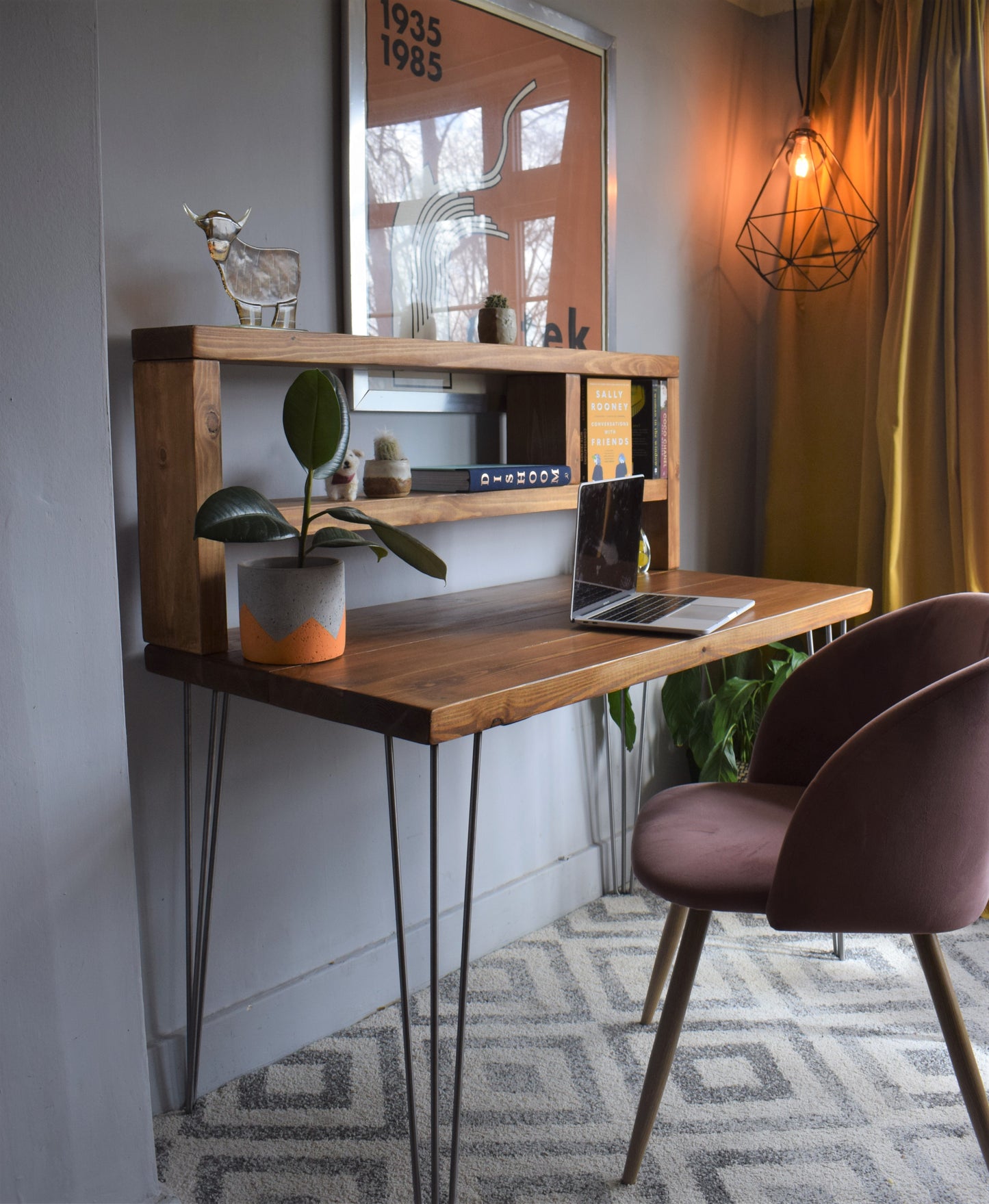 Angle view of industrial redwood pine desk showcasing raw steel hairpin legs and tall shelf.
