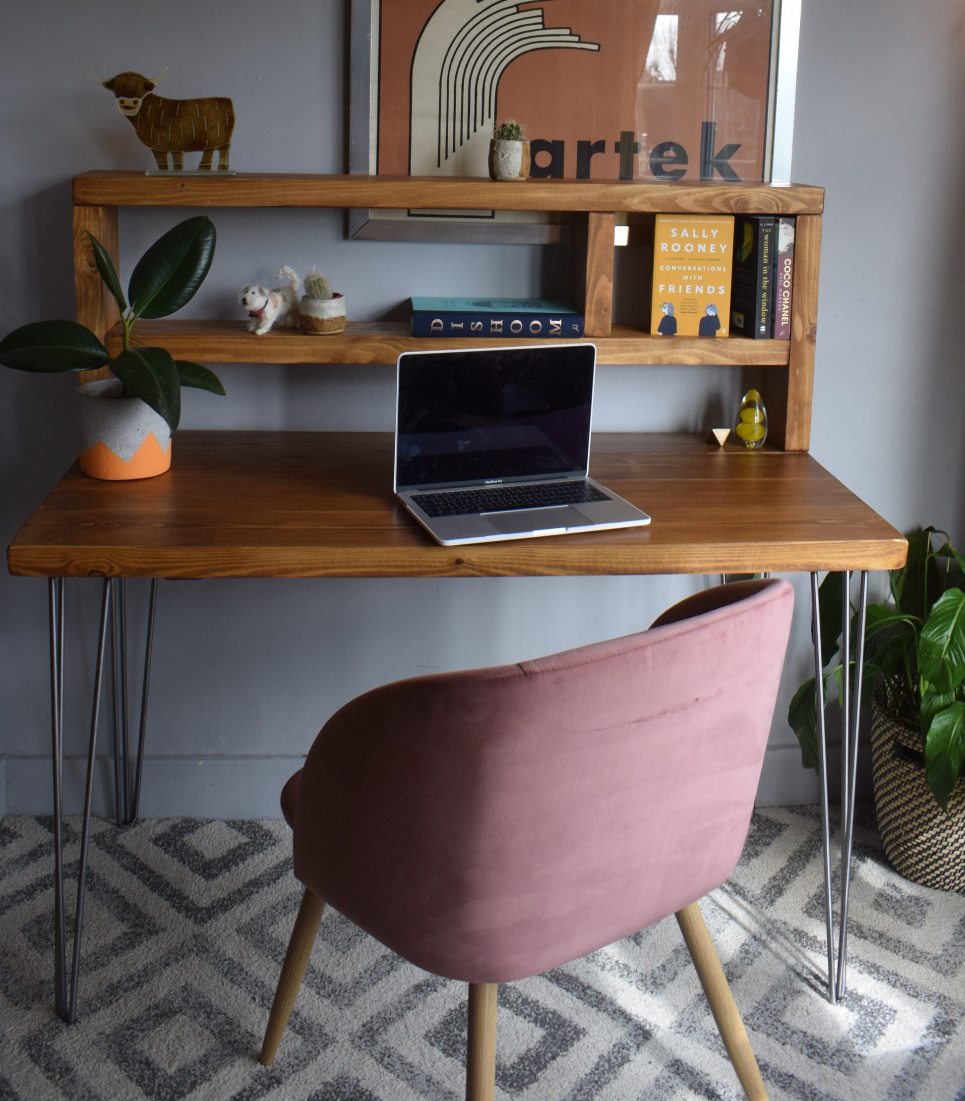 Industrial pine desk with raw steel legs and tall shelf in a modern office setting.