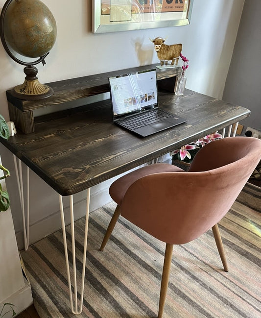 Industrial redwood pine desk with white steel hairpin legs and riser shelf for modern office use.